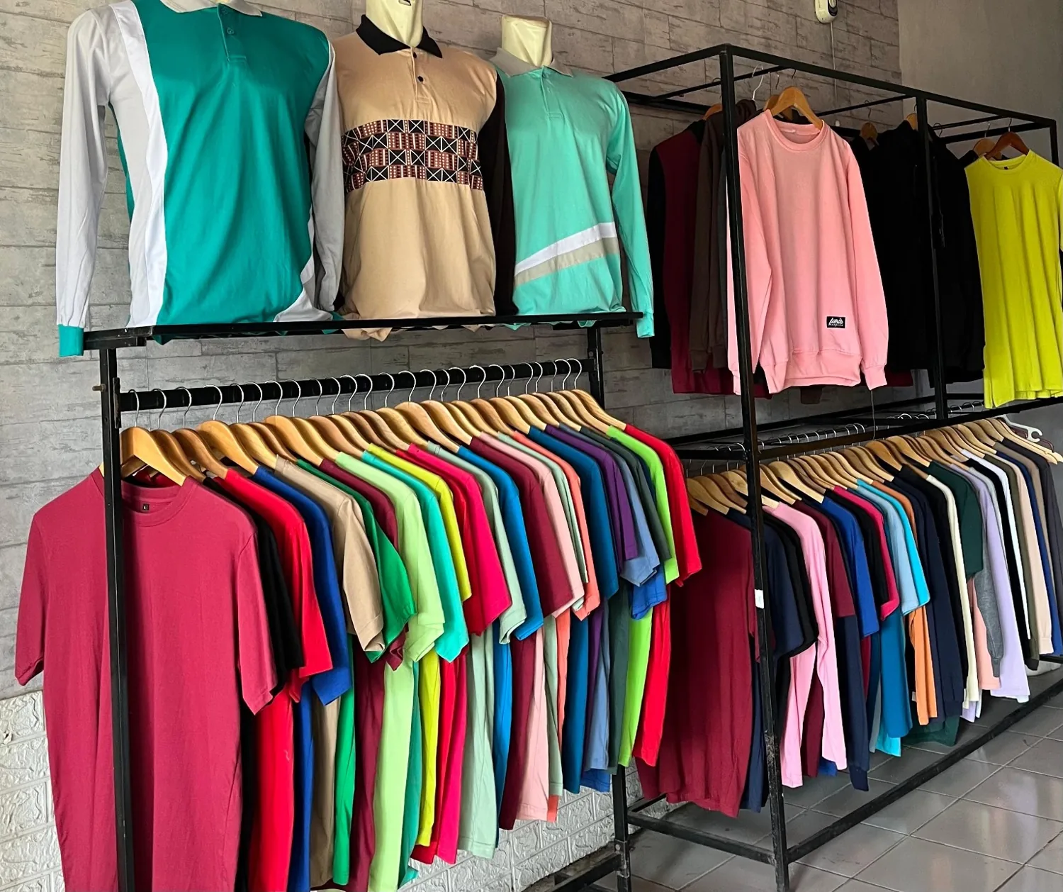 Rak koleksi kaos polos AJM dalam beragam warna