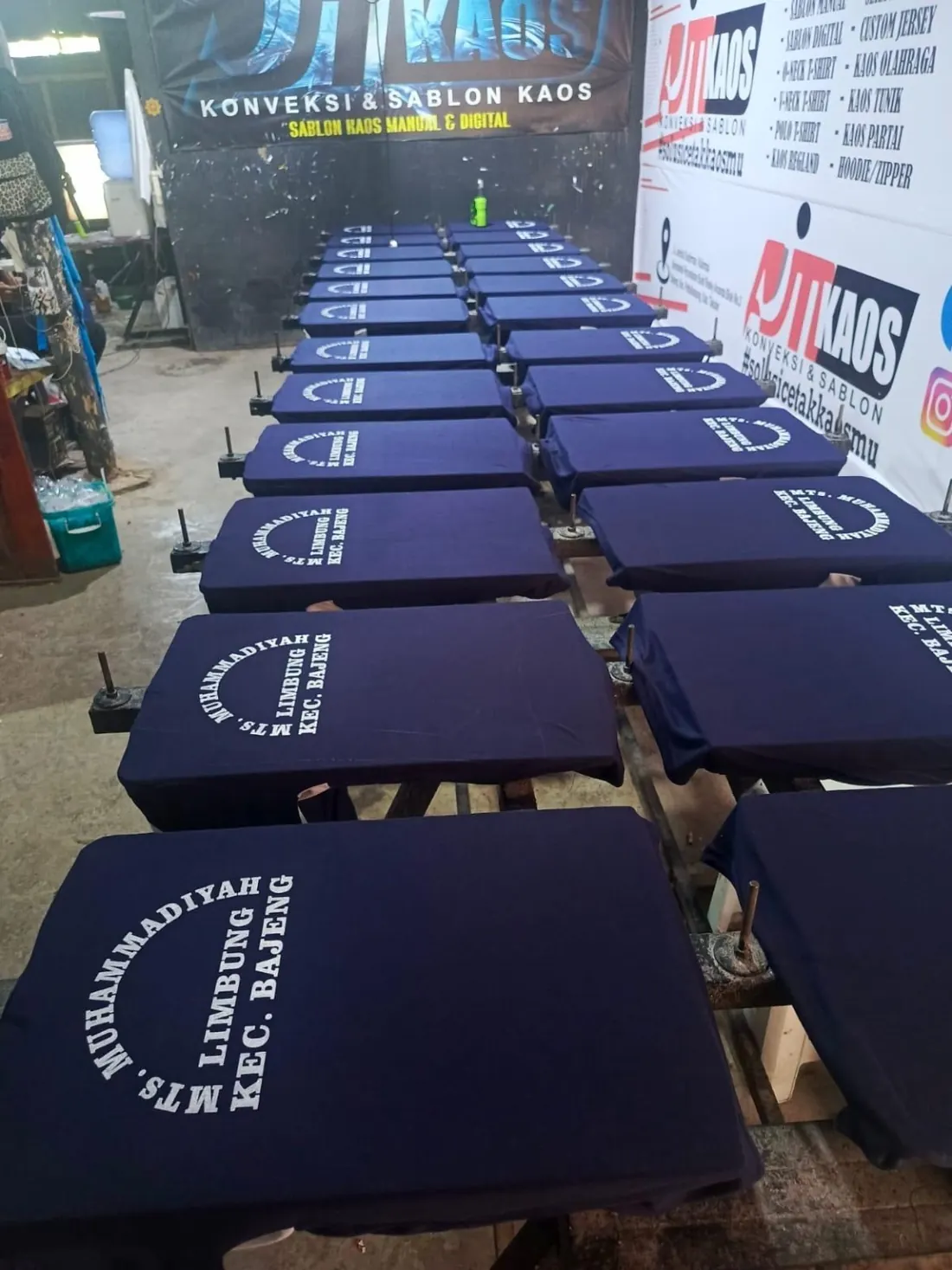 Deretan kaos biru tersusun saat proses sablon AJM