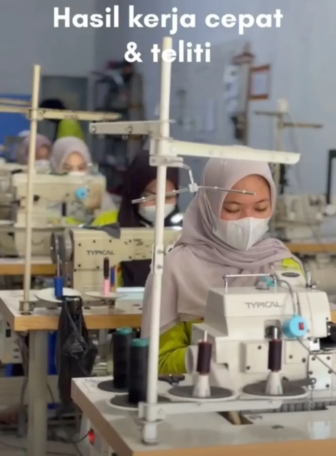 Penjahit mengoperasikan mesin di area produksi AJM
